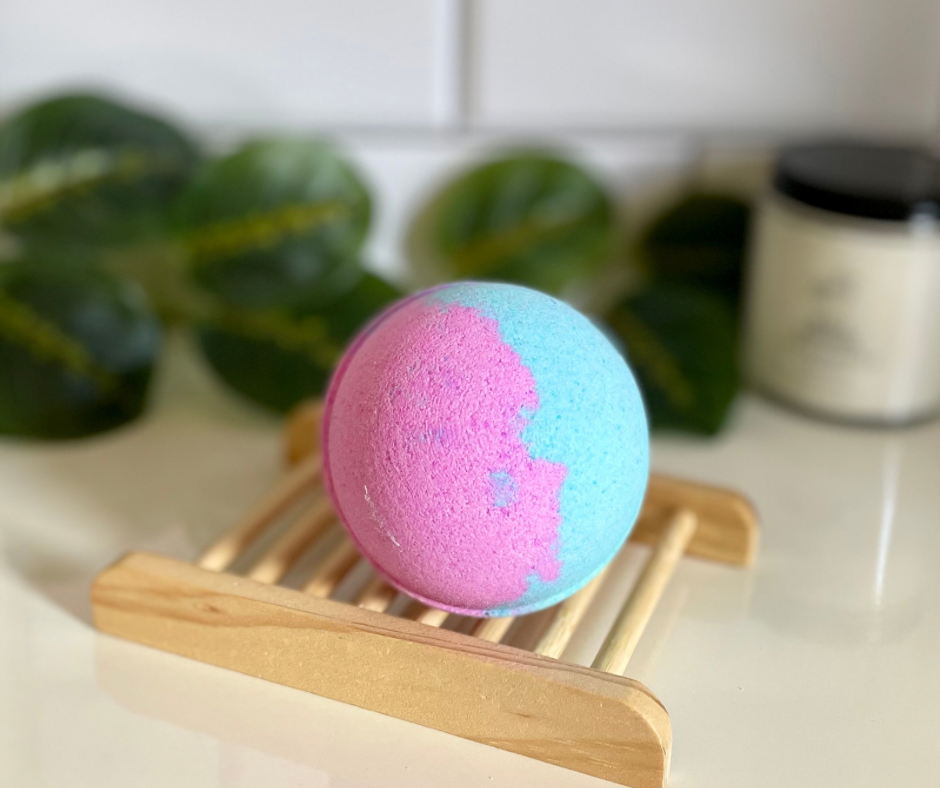 Blue and pink round bath bomb on wooden tray